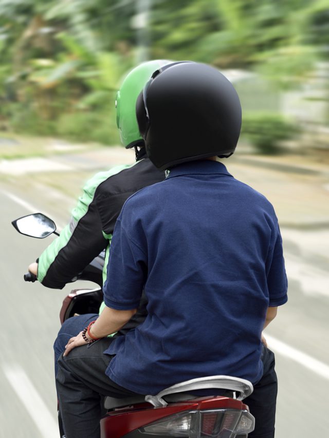 Portrait of motorcycle taxi driver delivering the passenger to his destination