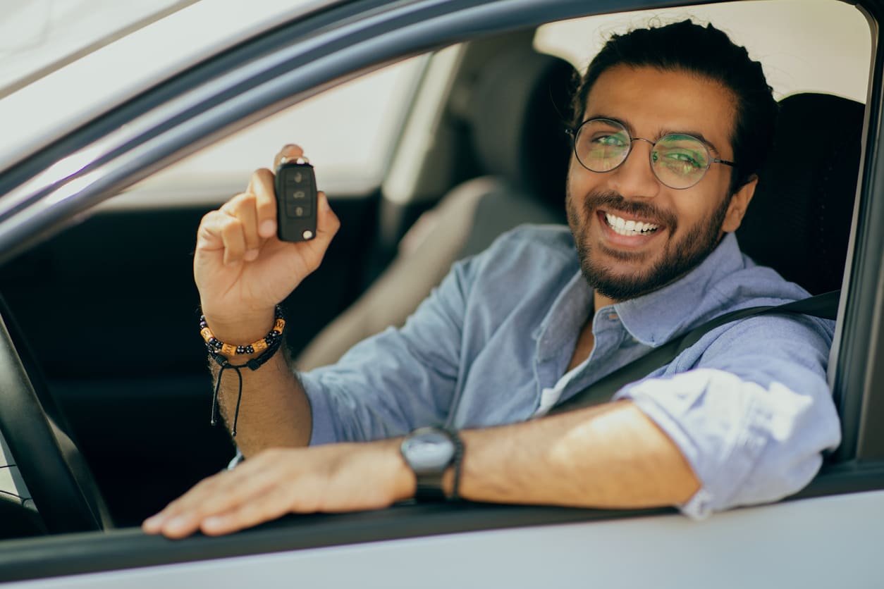 homem dentro do carro segurando a chave do veiculo